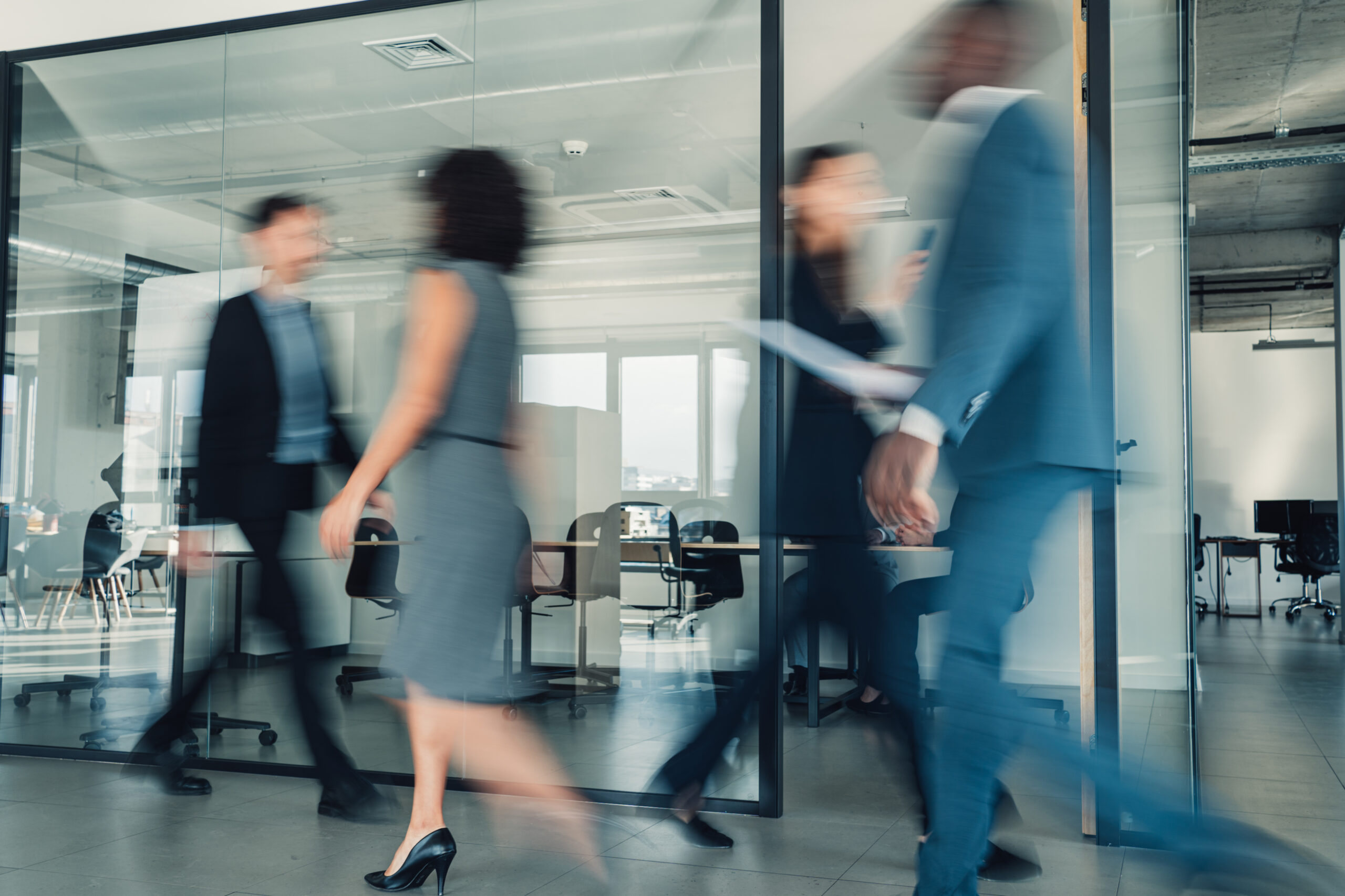 People walking outside a meeting room in an office